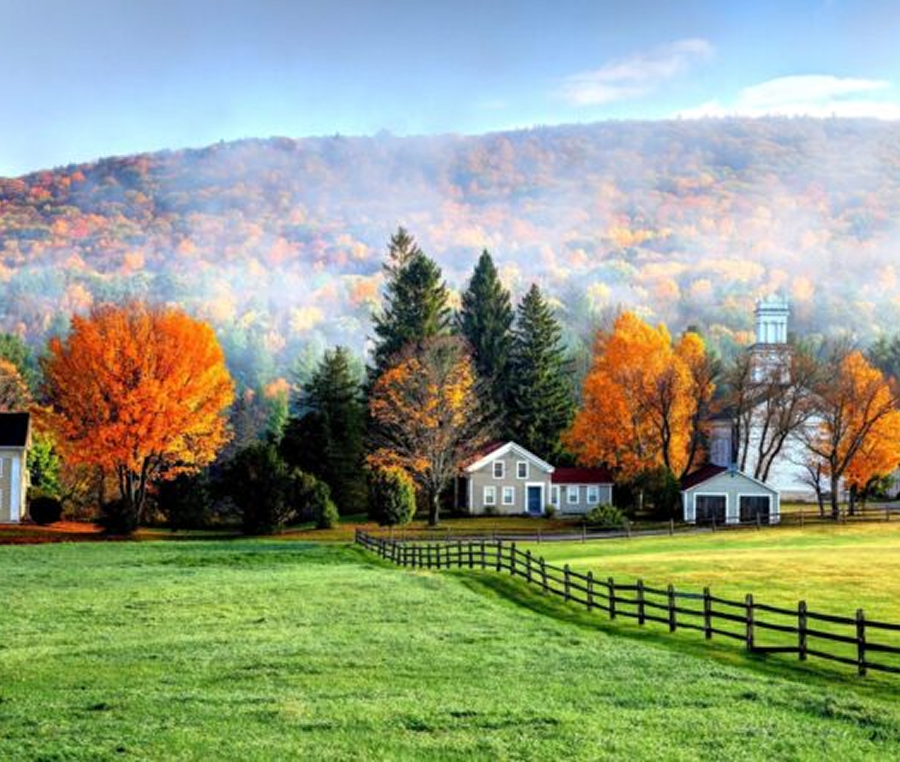 Autumn countryside with colorful trees and houses.